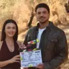 Özge Yağız y Halit Özgür Sarı posan con la claqueta de Tell Me Troy durante el rodaje